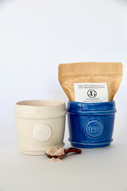 Two ceramic containers, one beige and one blue, with a brown bag labeled 'L&G' on a white background.